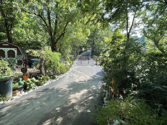 Smooth, curvy, paved driveway lined with trees